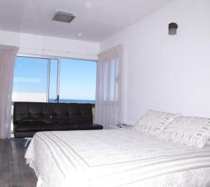 Un dormitorio con una cama grande y una ventana grande. en Delamar Suites 2 y 3, en La Paloma