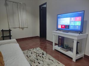 sala de estar con TV de pantalla plana sobre una mesa en Sueño Luqueño en Luque