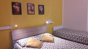 twee bedden in een kamer met posters aan de muur bij Bolognamania Apartments-Smart in Bologna