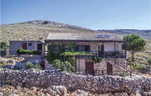 a stone house with a stone wall in front of it at Amazing Home In Kornati With House Sea View in Vrulje