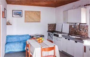 a kitchen with white cabinets and a table with fruit on it at Amazing Home In Kornati With House Sea View in Vrulje