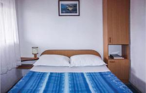 a bedroom with a bed with a blue and white blanket at Amazing Home In Kornati With House Sea View in Vrulje