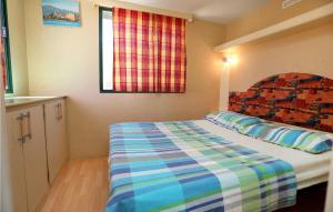 a small bedroom with a bed and a window at Amazing stacaravan In Trogir With Kitchen in Trogir