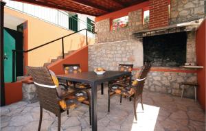 a table and chairs on a patio with a fireplace at Awesome Home In Sparadici With 2 Bedrooms And Wifi in Grebaštica