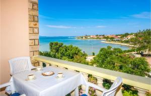 a table and chairs on a balcony with a view of the ocean at Beautiful Apartment In Privlaka With Kitchen in Privlaka