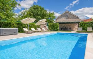 een groot zwembad met stoelen en parasols bij Lovely Home In Glavina Gornja With Private Swimming Pool, Can Be Inside Or Outside in Gornja Glavina