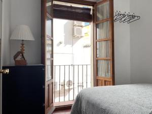um quarto com uma porta que abre para uma varanda em Hispalis San Julian em Sevilha