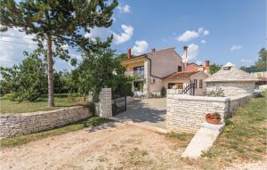 a house with a stone fence in front of a yard at 2 Bedroom Amazing Apartment In Kanfanar in Kanfanar