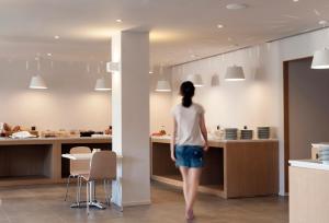a woman is standing in a kitchen at Kriti Hotel in Chania