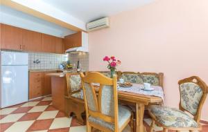 a kitchen with a wooden table and chairs and a kitchen with a refrigerator at Nice Apartment In Labin With Outdoor Swimming Pool in Diminići