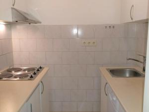 a white tiled kitchen with a sink and a stove at Apartment in Maria Alm near ski area in Maria Alm am Steinernen Meer