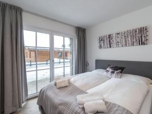 ピーゼンドルフにあるLavish Apartment in Salzburgerland near Ski Areaのベッドルーム1室(ベッド1台、大きな窓付)