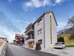 un edificio bianco con un'auto parcheggiata di fronte di Modern apartment in St Georgen near Salzburg a Fürstau