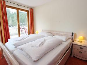 sypialnia z 2 białymi łóżkami i oknem w obiekcie Large chalet apartment in Saalbach-Hinterglemm w Saalbach Hinterglemm