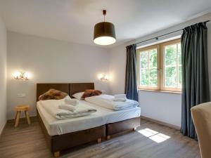a bedroom with a bed and a large window at Chalet in Hollersbach Salzburg near ski area in Hollersbach im Pinzgau