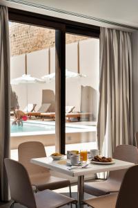 a dining room with a table and a swimming pool at Kriti Hotel in Chania Town