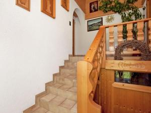 eine Treppe in einem Haus mit einem Holzgeländer in der Unterkunft Apartment with terrace ideal for skiers in Kaunerberg