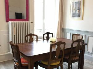 uma mesa de jantar com cadeiras e um radiador em Gîte Saint-Nicolas-de-Port, 4 pièces, 6 personnes - FR-1-584-179 em Saint-Nicolas-de-Port