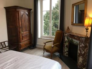 Schlafzimmer mit einem Bett, einem Kamin und einem Fenster in der Unterkunft Gîte Saint-Nicolas-de-Port, 4 pièces, 6 personnes - FR-1-584-179 in Saint-Nicolas-de-Port