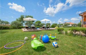 Banda zabawek na trawie na podwórku w obiekcie Two-Bedroom Holiday Home In Tinjan w mieście Tinjan