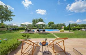 patio z krzesłami i stołem oraz basenem w obiekcie Two-Bedroom Holiday Home In Tinjan w mieście Tinjan