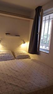 een slaapkamer met 2 bedden en een raam bij Cap Esterel appartement rénové VUE MER MAGNIFIQUE ! in Drammont