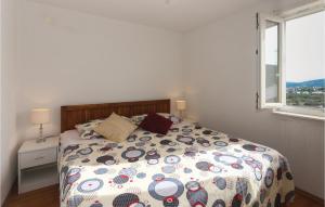 a bedroom with a bed with a comforter and a window at Beautiful Apartment In Slatine With 1 Bedrooms And Wifi in Slatine