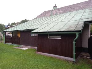 a house with a metal roof on the side of it at Apartmán u Kynských in Horní Lánov