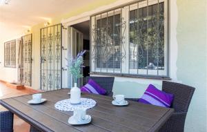 a wooden table with purple pillows on a porch at Gorgeous Apartment In Pavicini With Kitchen in Pavicini