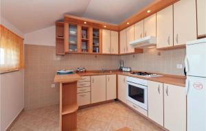 a kitchen with white appliances and wooden cabinets at Awesome Apartment In Krusevo With 2 Bedrooms And Wifi in Kruševo