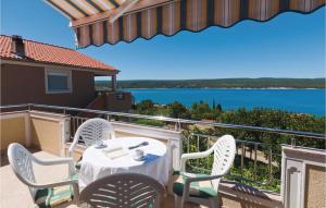a table and chairs on a balcony with a view of the water at Awesome Apartment In Krusevo With 2 Bedrooms And Wifi in Kruševo