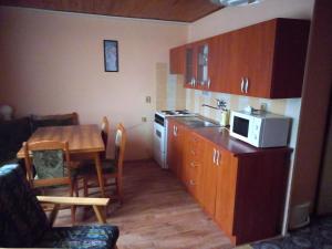 a small kitchen with a table and a microwave at Apartmán u Kynských in Horní Lánov