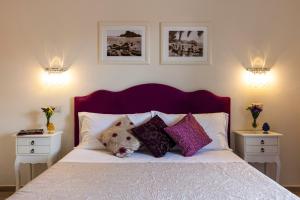 a bedroom with a bed with pillows and two night stands at Valentina in Taormina