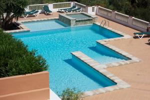 una piscina con acqua blu in un cortile di Petit Paradis a Son Bou