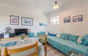 a living room with a blue couch and a table at Stunning Apartment In Tribunj With 1 Bedrooms in Tribunj