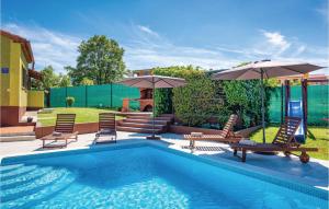a swimming pool with two chairs and umbrellas at Nice Home In Skitaca With Wifi in Šajini