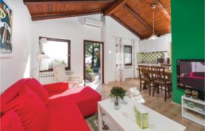 a living room with a red couch and a table at Amazing Home In Pobri With House Sea View in Volosko