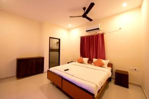 1 dormitorio con 1 cama y ventilador de techo en Thiru Pavilion Retreat en Mahabalipuram