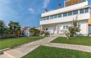 a large white house with a yard at Beautiful Apartment In Novigrad in Novigrad Istria
