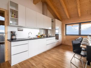 a kitchen with white cabinets and a table and chairs at Chalet in Klippitzt rl ski area with sauna in Klippitztorl