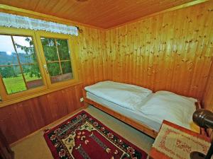 Cama pequeña en habitación de madera con ventana en Holiday home in Sibratsgf ll in the Bregenzerwald en Sibratsgfäll