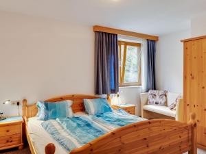a bedroom with a large wooden bed with blue pillows at Apartment near the ski area in Matrei in Matrei in Osttirol