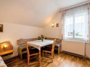 a dining room with a table and chairs and a window at Beautiful apartment with swimming pool in Tröpolach