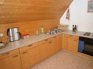 DeutschgriffenにあるHoliday home in Deutsch Griffen near Woertherseeのキッチン(木製キャビネット、シンク付)