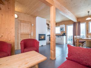 ホーエンタウアーンにあるChalet in Hohentauern near ski area with saunaのリビングルーム(赤い椅子、テーブル付)