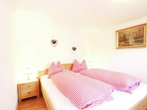 sypialnia z łóżkiem z białymi i czerwonymi poduszkami w obiekcie Chalet in Kufstein near Ski School w mieście Niederndorferberg