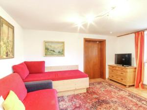salon z czerwoną kanapą i telewizorem w obiekcie Chalet in Kufstein near Ski School w mieście Niederndorferberg