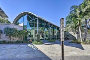 尔湾Modern Irvine Condo with Pool - 7 Mi to Beach!的一座玻璃建筑,前面有一棵棕榈树