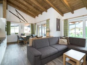 a living room with a couch and a table at Penthouse with sauna in Piesendorf Salzburgerland in Piesendorf