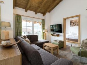 a living room with a couch and a tv at Penthouse with sauna in Piesendorf Salzburgerland in Piesendorf